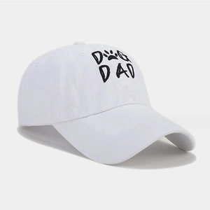 Close-up of the black DOG DAD embroidery and paw print on a white cotton baseball cap