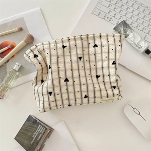 Vue de dessus de la trousse à maquillage à carreaux et cœurs en tissu gaufré texturé