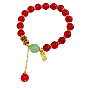 Gros plan d'un bracelet de perles vintage avec perles d'agate rouge et breloque Ping An