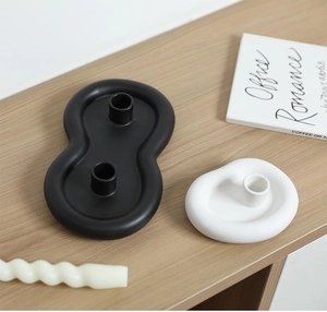 Detail view of Nordic cloud ceramic candle holders with spiral wax candle on a wood desk