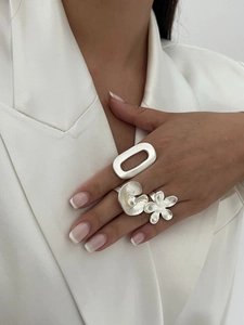 Detailed view of matte silver minimalist ring set with flower design and single pearl