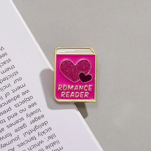 Detail of pink enamel book brooch with glitter heart and Romance Reader engraving
