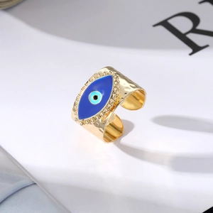 Detail of gold evil eye ring with blue enamel and hammered metal texture finish