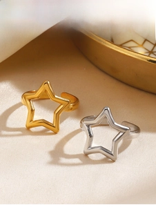 Close-up of gold and silver hollow star open rings on a soft velvet surface