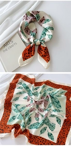 Detail of silk square scarf featuring green leaf patterns and leopard print borders