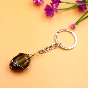 Macro view of polished tiger eye gemstone with handmade wire wrapping on a keychain