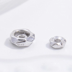 Macro shot of S925 sterling silver faceted spacer beads showing authentic hallmarking
