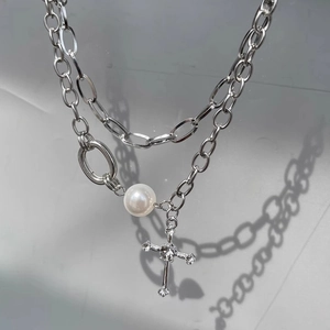 Double-layered necklace featuring a cross pendant and white pearls on silver chain