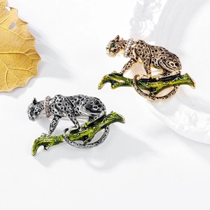 Vintage alloy leopard brooches in gold and silver finish with green enamel leaf accent