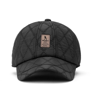 Detail view of black quilted baseball cap with diamond stitching and leather logo patch