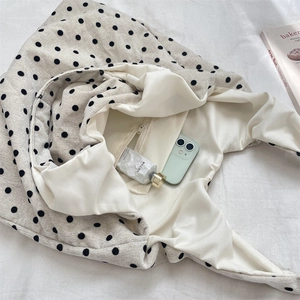 Internal view of a polka dot canvas tote bag showing the zipper pocket and large capacity