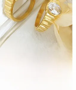 Close-up of a gold-plated striped band ring featuring a round sparkling zircon stone