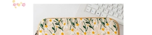 Close-up of daisy floral embroidery and fine texture on beige canvas iPad laptop sleeve