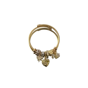 Detailed close-up of golden multi-layer braided wire bracelet with heart and butterfly charms