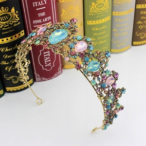 Detailed view of a vintage gold crown with colorful crystals on decorative books
