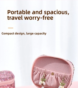 Detail of pink sequin jewelry box showing elastic pocket with pearl earrings