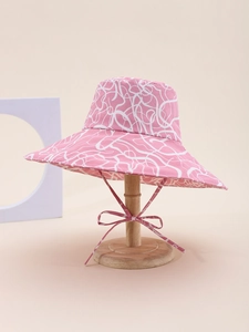 Detail of pink wide-brim sun hat with white abstract patterns and windproof ribbon