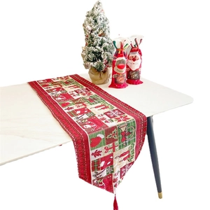 Christmas table runner with Santa, reindeer and tassel motifs on a festive dining setup