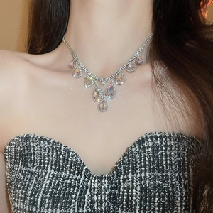 Close-up of a luxury silver teardrop pendant necklace with sparkling zircons on a model