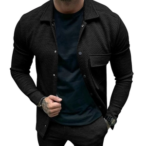 Detail of black twill textured jacket showing metal snap buttons and chest pocket