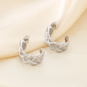 Détail des boucles d'oreilles argentées en forme de C avec texture chaîne sur soie