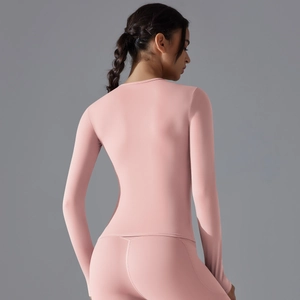 Rear view of pink slim-fit long sleeve yoga top showing seamless stretch fabric quality
