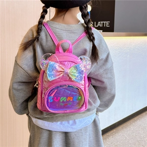 Pink sequin backpack for girls with ears and rainbow bow design shown on a model