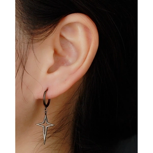 Detail shot of black stainless steel cross star hoop earrings worn by a model