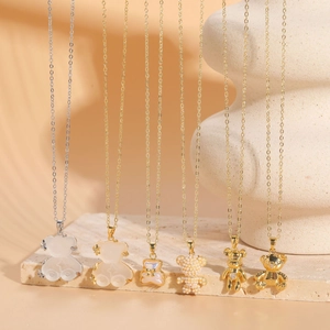 Vue détaillée de pendentifs ours en résine dorée 14K et perles aux textures variées