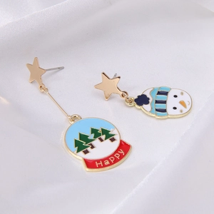 Detail of asymmetric Christmas earrings with snowman and festive snow globe pendants