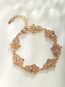Détail du bracelet main de Fatma dorée avec motifs ajourés et strass étincelants