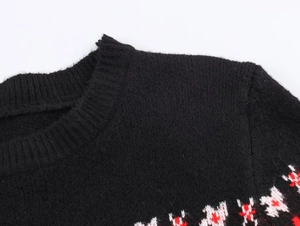 Détail d'un pull en maille noir avec motif jacquard nordique au col et à l'épaule