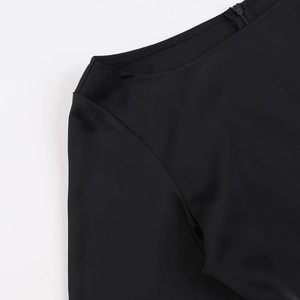 Détail de l'épaule d'une robe en satin noir élégante avec couture fine et texture de tissu