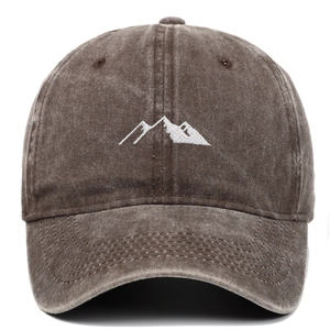 Close-up of white mountain embroidery on a vintage washed brown cotton baseball cap