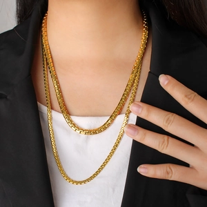 Golden double layered box chain necklace worn by model for a modern minimalist look