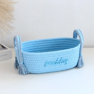 Close-up of blue cotton rope storage basket featuring tassel handles and 3D goodday text