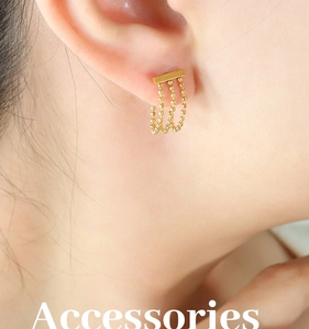 Détail macro de boucles d'oreilles à franges triple chaîne dorée sur l'oreille