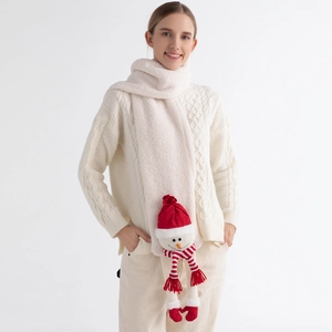 Detail of cream plush winter scarf featuring a cute 3D snowman doll with red hat