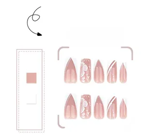 Detail of nude pink press-on nails with white French V-tips and 3D floral accents