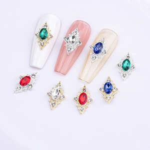 Macro shot of rhombus nail art charms with colorful gems and gold silver metal bases