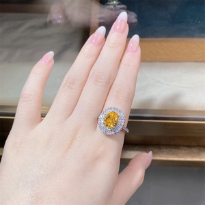 Detail of s925 silver ring featuring an oval yellow gemstone with double halo diamonds