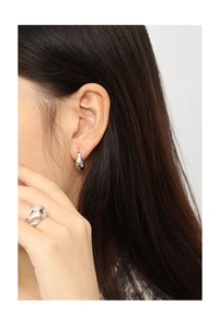 Close-up of minimalist S925 sterling silver U-shaped earring and chunky hollow ring