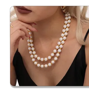 Close-up of double-layered pearl necklace with golden beads on elegant female model