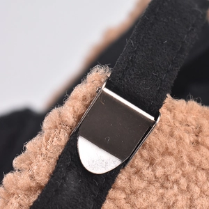 Macro detail of silver metal adjustable buckle and plush brown faux fur baseball cap