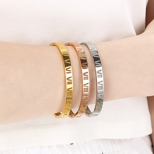 Lot de trois bracelets en acier inoxydable avec chiffres romains aux poignets du mannequin