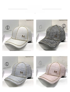 Detailed view of tweed baseball caps in four colors featuring a gold metal M logo and bead trim