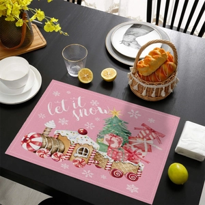 Detailed view of pink Christmas placemat with watercolor Santa and let it snow text