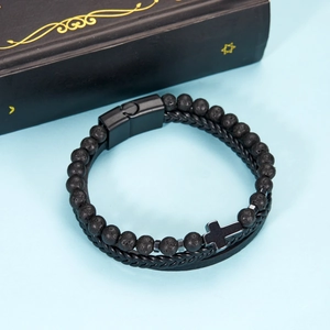 Detail of multi-layer leather bracelet with volcanic stone beads and a black metal cross