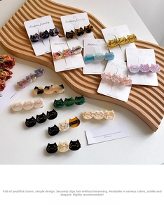 Detailed close-up of cat-shaped acetate hair clips in various marble and tortoiseshell patterns