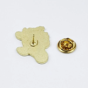 Detailed view of the gold metal badge back featuring a secure butterfly clutch pin backing